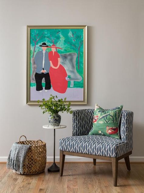 A round marble and bronze accent table sits beside a blue geometric accent chair positioned under a large framed painting hung from a light gray wall. White Upholstered Chair, Marble Top Accent Table, Brass Accent Table, Marble Accent Table, Wrought Iron Staircase, Modern Accent Tables, Marble Top Coffee Table, Sitting Chair, Mirrored Coffee Tables