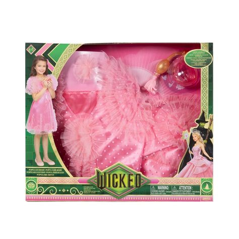 Fans of Universal Pictures’ Wicked will love playing dress up with this fun look inspired by one of Glinda’s most exciting songs! Act out one of your favorite scenes as Glinda, while dressed in this nightgown style “Popular” dress with layers and pinwheels of ruffles. Deluxe Dress Up Set includes 1 pink “Popular” dress with gathered sleeves and ruffles. Comes with 2 accessories - use Glinda’s Perfume Bottle and Rosette Hairclip to finish your popular style! Only available at TARGET. Wicked Merch 2024, Glinda Popular, Wicked Merch, Wicked Dolls, Dream Daughter, Dress With Layers, Wicked Movie, Popular Dress, Glinda The Good Witch