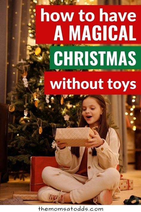 How to have a magical Christmas without toys. Photo of child sitting under Christmas tree with a gift. How To Make Christmas Special For Kids, No Toy Christmas For Kids, Magical Christmas For Kids, Christmas Presents For Toddlers, Christmas Traditions Around The World, Make Christmas Magical, Non Toy Gifts, Gift Ideas For Kids, Christmas Traditions Family