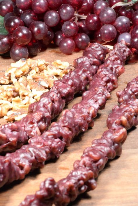 Georgian Chuchkhelala is a delicious candy made with walnuts or hazelnuts strung on a sting and then dipped into a thick candy like mixture of grape or other fruit. This candy is loved all over the country and you will see them hanging up drying in many villages. Walnut Candy, Georgian Desserts, Georgia Food, Georgian Cuisine, Georgian Food, Italian Pizza Recipe, Armenian Recipes, Looks Yummy, Types Of Food