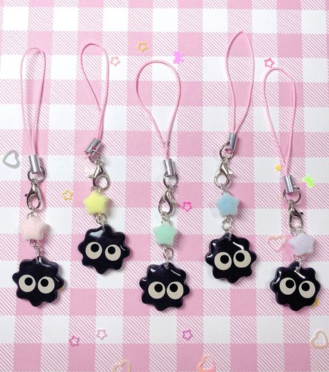 ♡ Introducing our handmade polymer clay phone charms inspired by the adorable soot spirits from the beloved anime films! These charming phone accessories are the perfect way to show your love for the movie and add some whimsical flair to your phone.  ♡ Each charm is carefully crafted and painted by hand to ensure that it captures the essence of the soot spirits, with five different styles to choose from and three different phone cord colors to match your style! You can attach them to your phone, bag, or even your keys - they're perfect for adding a touch of cute and unique style to any item. These phone charms make a great gift for any Ghibli fan or anime lover, or treat yourself to one and keep the magic of the movie with you wherever you go! Note: The star beads are flocked/fuzzy! ♡ Care Polymer Clay Friendship Charms, Cute Clay Accessories, Useful Things To Make With Clay, Kpop Clay Ideas, Polymer Clay Phone Charms, Anime Phone Charms, Polymer Clay Cute Charms, How To Make Phone Charms, Clay Charms Diy