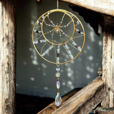 This stunning gold and garnet suncatcher is adorned with a dazzling glass spider and quartz crystals, bringing whimsy and wonder to your space! The delicate hand-made design features quartz and garnet crystals wrapped around a gold hoop with a delicate glass-beaded spider in the middle. Larger glass prisms dangle below to catch the light and create a mesmerizing display of rainbows.    Hang this one of a kind sparkly spider design in a sunny window to enjoy its shimmering beauty all day, or enjoy it as a unique and eye-catching accent in any space. The sun will shine through all of the stones and glass prisms. Handcrafted with care and attention to detail, this quartz crystal spider sun catcher is a genuine work of art that will bring joy and inspiration to your home for years to come! Det Copper Suncatcher, Window Sun Catchers, Hanging Crystals Diy, Crystal Spider, Beaded Suncatcher, Copper Wire Crafts, Glass Spider, Spider Design, Dream Catcher Craft