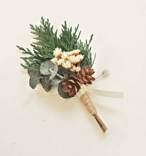 "This fragrant, natural cedar boutonniere creates a sweet and simple winter-inspired look. It features sprigs of dried natural cedar and  eucalyptus along with miniature pine cones and little groups of ivory flowers. Jute twine base with a little ivory ribbon accent tie.   DETAILS  ♥ Listing is for one boutonniere. ♥ Each measures about 4\" tall ♥ Pin included. ♥ Wrist corsage available! -- WG" Winter Wrist Corsage, Winter Boutineer Groomsmen, Cedar Boutonniere, Pine Boutonniere, Evergreen Boutonniere, Forest Boutonniere, Winter Wedding Groomsmen, Antler Boutonniere, Rustic Winter Wedding Ideas