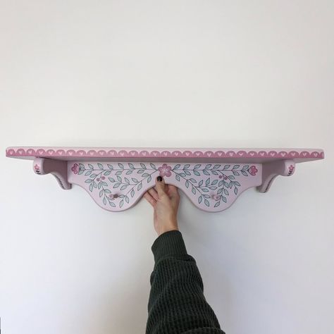 Little pink wooden shelf 🩷 #handpainted #handpaintedfurniture #handpaintedhomedecor #colorfulhome #colorfulinterior #interiordesign #folkart #boho #uniqueinteriors #fusionmineralpaint #smithfieldva #virginiaartist #upcyclefurniture #upcycle Folk Art On Furniture, Hand Painted Shelf, Painting Shelves Ideas, Folk Painted Furniture, Flower Border Ideas, Shelf Painting Ideas, Lesbian Cottage, Painted Wall Shelf, Folk Art Furniture