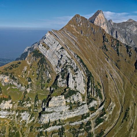 Aerial view of the Sichelkamm mountain, #Switzerland. The huge fold (syncline) in the flank of the Sichelkamm mountain is an impressive witness of the collision between Africa and Europe. The layers, originally deposited on the sea floor in a horizontal position, were compressed and shifted. The large fold is formed by Cretaceous limestone of the so-called Säntis nappe. Aerial Views Landscape, Mountain Switzerland, Mountain Formation, Geology Art, Sea Floor, Rocks And Fossils, Earth Surface, Geology Rocks, Mountain Photography