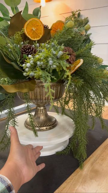 Jessica Billings on Instagram: "The Winter Greenery Arrangement is made on a brass compote bowl and is spilling over with faux Cedar, Pine, Juniper, Eucalyptus and Pine Cones and finished with real dried oranges. Free domestic shipping. Available to purchase on the website now. 🍊 🌿" Greenery Arrangements, Dried Oranges, Christmas Table Decorations, Christmas Table, Pine Cones, Winter Holidays, Winter Wedding, Floral Arrangements, Fall Decor