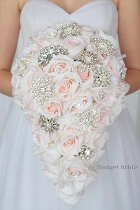 This brides’ bouquet is elegant, glamorous, and perfect if you have blush as one of the accent colors in your wedding. This vibrant and enchanting bouquet does not fall short on glitz and glamor – there are plenty of dazzling accent gems and jewels. Offering a new twist on the classic rose bouquet, this stunning arrangement is made using countless blush roses, as well as silver accent jewels that add an extra ounce of elegance. It is worth noting that we also have gold accent gems for those who Cheap Vibrant Blue Dress, Luxury Pink Embellishments For Wedding, Metal Flower Wedding Bouquet, Wedding Bouquet Gold Dress, Colored Wedding Flowers, Wedding Flowers Cheap, Bridal Colors, Green Wedding Bouquet, Red Bouquet Wedding