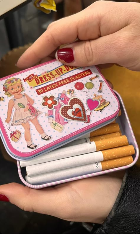 a woman with red nail polish holds a tin with stickers on it containing cigarettes Dollete Aesthetic, Altoids Tins, Inside My Bag, Mint Tins, Punk Princess, Small Tins, Aesthetic Coquette, Diy Metal, Tin Boxes