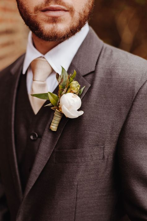 This groom’s boutonnière featured a single white ranunculus bulb and light greenery, a beautiful contrast to his dark grey suit. See more details from this luxe ivory and white wedding in Nashville, Tennessee, over on the blog! Dark Beige Groom Suit, Groom Dark Grey Suit, Tuxes For Weddings, Dark Gray Tux Wedding, Charcoal Groom Suit, Charcoal Gray Suit Wedding, Dark Grey Suit Wedding, Dark Grey Groom Suit, Grooms Tux Ideas