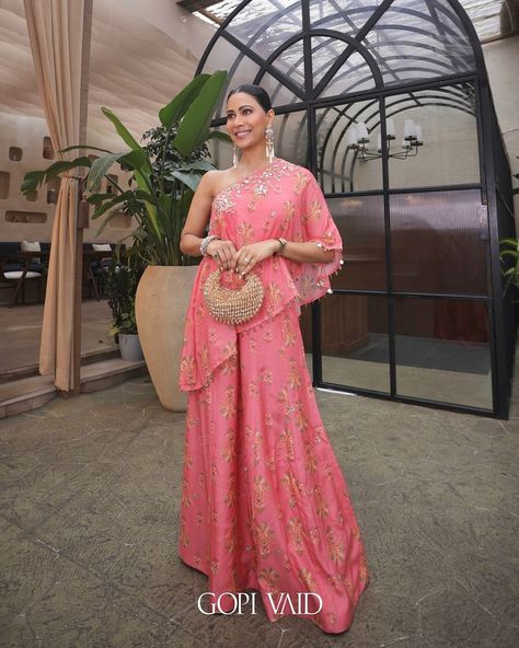 𝐒𝐰𝐚𝐭𝐢 𝐕𝐚𝐭𝐬𝐬𝐚 turns heads in this stunning pink ensemble, flaunting a one-shoulder top embellished with intricate gold embroidery and paired with matching flared pants. ✨ Designed by #𝐆𝐨𝐩𝐢𝐕𝐚𝐢𝐝, this outfit is the epitome of effortless luxury. Whether you’re dressing up for a festive occasion or simply making a statement, this ensemble is sure to leave a lasting impression. ✨ Discover this exquisite look now at Auraya Fashion. www.aurayafashion.com #aurayafashion #swativatssa #gopivaid #fest... Gopi Vaid, Bridesmaid Saree, Pant Sets, Gold Embroidery, Indian Outfit, Flared Pants, Modern Vibe, One Shoulder Tops, Flare Pants