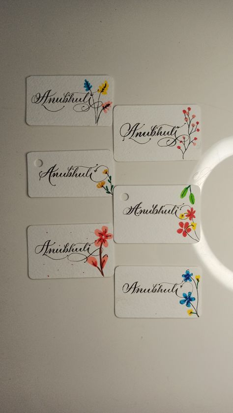 Anubhuti written in different ways , name tags in Copperplate Calligraphy, A in Copperplate Calligraphy, simple flower designs on tags, cute name tags, simple and elegant name cards Calligraphy Name Tags, Aesthetic Name Tag, Cute Name Tags, Calligraphy Simple, Calligraphy A, Simple Card Designs, Name Tag Design, Name Plate Design, Elegant Names