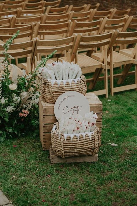 Confetti station for outdoor wedding ceremony at countryside surrey wedding venue Millbridge Court | Wedding stationery confetti signage by Paper Stories company styled with rattan baskets, summer white pink and green flowers and confetti wrapped in newspaper cones | Captured by Jason Harris Photography Confetti Stand Wedding, Rustic Wedding Aisle Outdoor, Spring Wedding Ceremony Decorations, Ceremony Confetti Toss, Wedding Program Basket, Wedding Aisle Confetti, Petals Wedding Ceremony, Ceremony Aisle Decor Outdoor Simple, Confetti Station Wedding