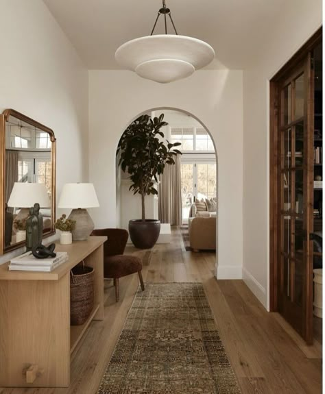 Archways are architectural design elements that not only enhance the aesthetic appeal of a space but also serve practical purposes. They are often used to connect rooms, creating a smooth transition between spaces. The curved structure of an archway adds a touch of elegance and can make interiors feel larger and more open. In design terms, archways can introduce a sense of drama and historical charm, making them a favored choice in many styles. Scandi Home Interior, Modern Boho Entryway Ideas, Neutral House With Pops Of Color, Small Living Room Minimal, Scandi Rustic Decor, Open Foyer Ideas Entryway, Minimal Cozy Home, Small Foyer Ideas Entryway, Eclectic Hallway