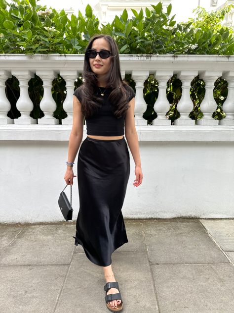 Satin Midi Skirt Outfits Party, Long Silk Skirt Outfit Casual, Black Midi Skirt Outfit Summer Casual, Silky Midi Skirt Outfit, Long Black Skirt Outfit Party Night, Midi Black Skirt Outfit Summer, Satin Skirt Black Outfit, Black Long Silk Skirt Outfit, Black Long Satin Skirt Outfit