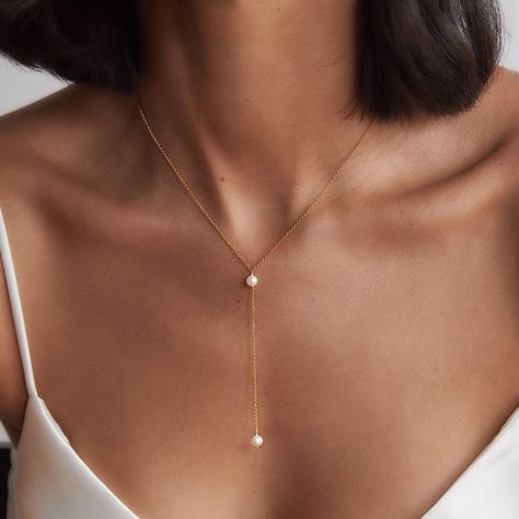 LILY & ROO's delicate gold pearl lariat necklace. Lovingly handmade in our London studio, this stunning lariat necklace is made from 14ct. gold filled chain and a genuine hand-selected freshwater seed pearl. The perfect jewellery for her. All gold pearl lariat necklaces come in a luxury LILY & ROO gift box as standard. Gold Filled means a layer of pure gold pressure-bonded to the core metal. Gold filled items are 5 to 10 times thicker than gold plating. Give your jewellery a little TLC to keep your jewellery shining bright. Your stunning single pearl lariat will be sent to you in a complimentary Lily & Roo gift box with ribbon tied in a beautiful bow. Silver Back Necklace, Elegant Wedding Necklace, Delicate Pearl Necklace, Minimalist Pearl Jewelry, Lariats Jewelry, Classy Jewelry Silver, Pearl Gold Jewellery, Pearl Necklace Designs Unique, Classy Gold Jewelry