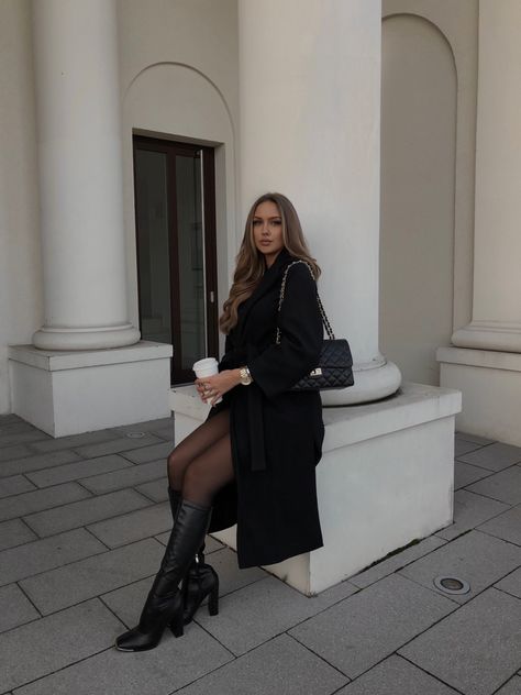 girl sitting in the city in front of white column with long wavy hair and a black oversize coat with leather high heel boots and a black chanel style bag with coffee in hand Black Coat Outfit Winter, Winter Fashion Inspiration, Black Coat Outfit, Leather Heel Boots, Oversize Coat, Outfit Oversize, Ootd Winter, All Black Outfit, Winter Days