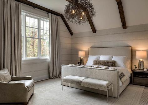 Gorgeous bedroom boasts gray shiplap walls under a sloped ceiling trimmed with dark stained wood beams over a cream linen bed with brass nailhead trim. Bedroom Dark Wood Bed, Beams Bedroom, Bedroom Beams, Wood Ceiling Bedroom, Bedroom Dark Wood, Sloped Ceiling Bedroom, Stained Wood Beams, Gray Shiplap, Dark Wood Bed