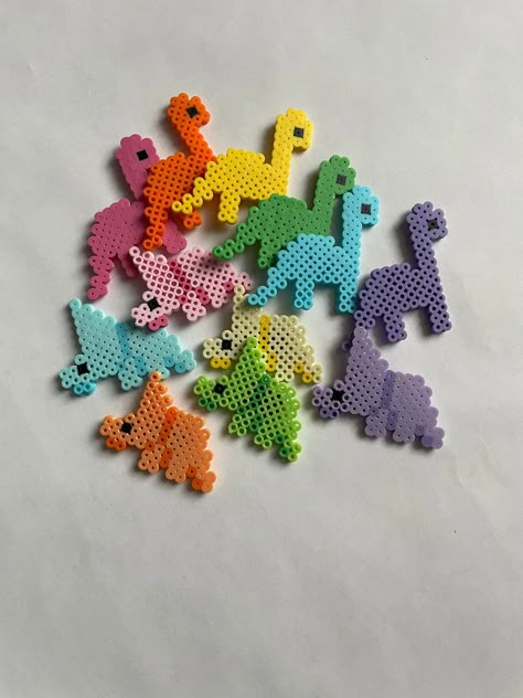 Small figures made with Perler Beads. Dinosaur  Tyrannosaurus Rex, Triceratops, and Brachiosaurus.  If you want a dinosaur or a color that isn't pictured let me know what you would like in the personalization box. If you don't want the magnet put on the back let me know in the personalization box and i'll just send the magnet unattached in case you want to add it later. Size:  Triceratops  Tyrannosaurus  Brachiosaurus  Made to order. If you have any questions please feel free to message me, I wi Succulent Perler Bead Pattern, Cute Pearler Beads Designs Ideas, Perler Beads Ideas Dinosaur, Perler Bead Orca, Dinosaur Pearl Beads, Ratatouille Perler Beads, Cute Melty Beads, Car Perler Bead Pattern, Cute Pearler Beads Ideas Easy