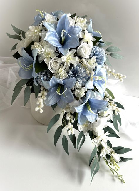 Pale Blue lilies , dusty blue dahlias , white peony , white roses , lilac , wattles , delphiniums , camellia foliage , eucalyptus  Cascading bridal bouquet . Finish with white ribbons  Bouquet is 50 cm (20inch) long and 32 cm (12inch) across. Bridesmaids matching lowers with white ribbons  Groom buttonhole Groomsmen buttonholes   cake topper set x 3 Wedding Bouquets Iris, Dark Blue Wedding Flowers, White And Blue Wedding Bouquet, Wedding Bouquets Lilies, Light Blue Wedding Bouquet, Baby Blue Bouquet, Cinderella Bouquet, Stargazer Lily Wedding Bouquet, Lilly Bouquets