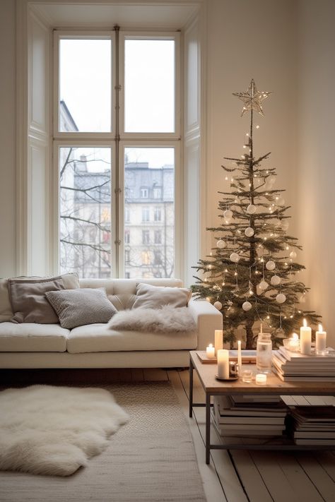 This minimalistic nordic holiday decoration fits a simple taste. The early 1900s apartment with large windows and wooden floors create a perfect setting for the white sofa with big pillows, white rug and fur on the floor, wooden coffee table with black metal frame, candles and medium sized christmas tree with elegant white decorations and lights. Simple Scandinavian Christmas, Minimalist Modern Christmas Tree, Nordic Christmas Tree Ideas, Scandinavian Christmas Living Room, Christmas Hygge Aesthetic, Minimalist Christmas Table Setting, Christmas Tree Modern Minimalist, 1900s Apartment, Christmas Tree Scandinavian Style