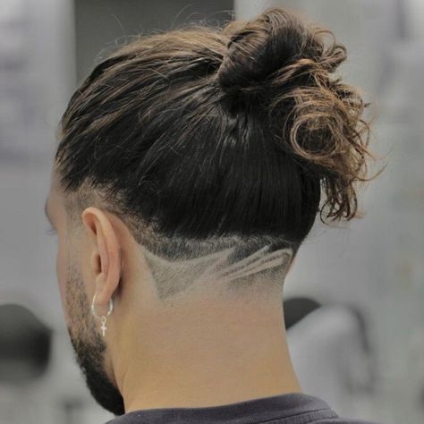 Explore the stylish and edgy look of a guy sporting a tied ponytail with a low fade haircut, enhanced by a pattern for added flair. Shaved Back Hairstyles, Long Hair With Taper, Boys Man Bun Haircut, Taper Men, Mens Long Hair Undercut, Mens Ponytail Hairstyles, Long Hair Fade, Man Bun Haircut, Trendy Ponytail