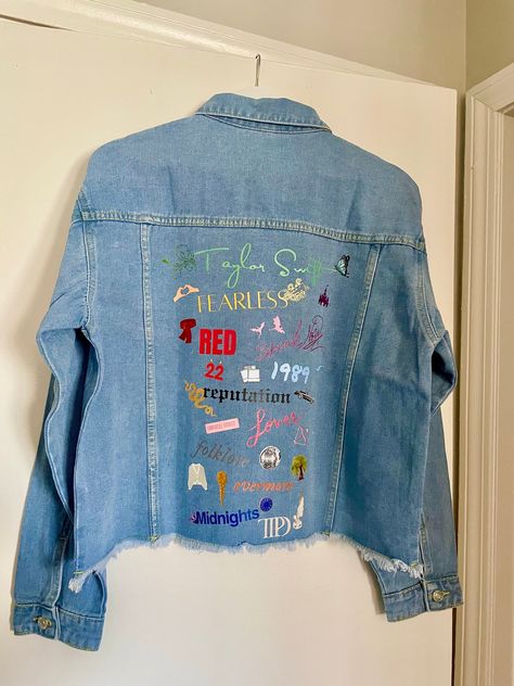 Stay in style with this classic medium wash denim jacket, customized to celebrate all of Taylor's iconic eras. Featuring images representing each album and various songs. Women's Jean Jacket Frayed Washed Button Up Cropped Denim Jacket With Pockets 65% Cotton, 35% Polyester Stylish raw hem, two chest fake pockets, two side slant hand pockets, turndown collar, button cuffs Design is DTF heat transfer decal, hand pressed.  Variations and small imperfections may occur as it is a handmade product, each design pressed individually. Taylor Swift Eras Denim Jacket, Eras Tour Painted Jacket, Taylor Swift Eras Jean Jacket, Swiftie Jean Jacket, Lover Jean Jacket Taylor Swift, Taylor Swift Jacket Diy, Taylor Swift Jean Jacket Diy, Eras Tour Jean Jacket, Eras Tour Denim Jacket