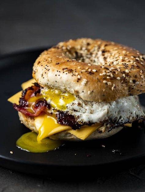 This Bagel Breakfast Sandwich is the perfect easy way to start the morning! Real deal thick bacon, fresh bagels, gooey cheese and sliced grilled onions truly make this the ultimate breakfast sandwich. Deli Breakfast Ideas, Bagel Burger Ideas, Blueberry Bagel Sandwich, Begal Sandwich, Breakfast Bagel Sandwich Ideas, Bagel Recipe Sandwich, Homemade Breakfast Sandwich, Bagel Sandwich Ideas, Breakfast Bagel Sandwich