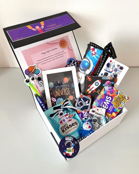 🚀Space-themed Rakhi Hamper for Lil Bro👨‍🚀 To the 🌜& 🔙 with love! Our rakhi hamper is out of this world, just like your younger brother. 🎁🧿 This beautiful box comes with the following goodies- • Pencil Box • Diary • Customizable Frame • 2-in-1 Rakhi • Keychain • Badge • Pen & Pencil • Eraser • Hand Band • Stickers • Hershey’s Kisses • Cadbury Gems • Crispello Price: ₹1999/- + shipping DM us to place your order 💌 No COD [Gift hampers, rakhi gifts, rakhi hampers, rakhi gifts2024, rakhi f... Gifts For Younger Brother, Cadbury Gems, Rakhi Hampers, Hampers For Her, Hand Band, Lil Bro, Band Stickers, Happy Rakshabandhan, Younger Brother