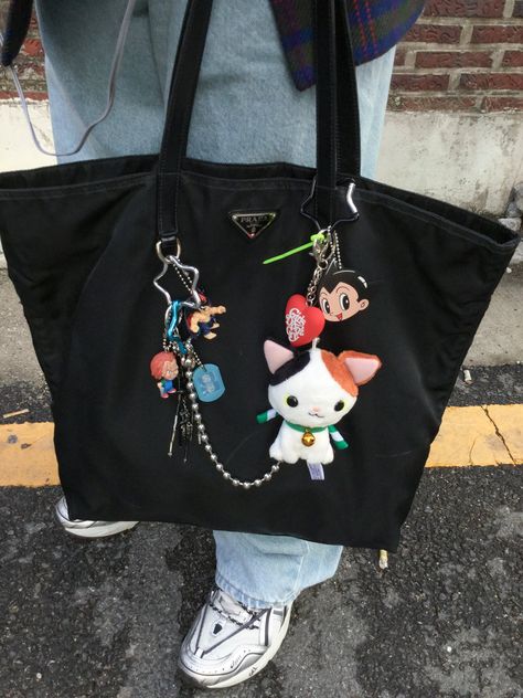 Cute Bag Charms Aesthetic, Baggu Keychain Aesthetic, Anik Anik Bag, Black Backpack Decoration, Tote Bag With Charms, Bags With Charms Aesthetic, Keychain Bag Aesthetic, Backpack Aesthetic Black, Bag Decoration Aesthetic