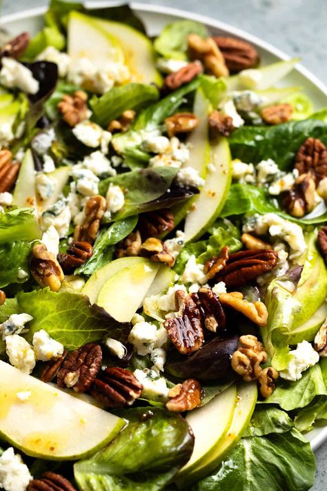 This simple pear and gorgonzola salad tastes anything but! Crisp pears, toasted nuts, and crumbled Gorgonzola shine over lettuce drizzled with a homemade spiced vinaigrette. Gorgonzola Salad Dressing, Baked Pears With Gorgonzola, Salad With Pears And Gorgonzola, Pear And Gorgonzola Salad, Walnut Gorgonzola Salad, Pear Garganzola Salad, Arugula Pear Gorgonzola Salad, Pear Walnut Gorgonzola Salad, Pear Gorgonzola Salad