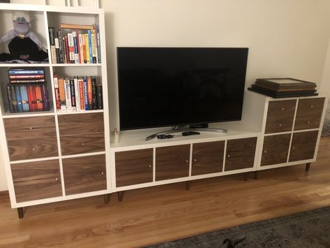 This is three Ikea Kallax units. I added legs from Prettypegs.com and covered the door and drawer front with walnut veneer I bought off Amazon.com. I also drilled a 2” hole for cable management so all the cables are well hidden. Ikea Kallax Tv Unit, Ikea Kallax Hack Tv Stands, Kallax Entertainment Center, Kallax Tv Unit, Ikea Cube, Tv Hidden, Diy Kallax, Kallax Unit, Ikea Cubes