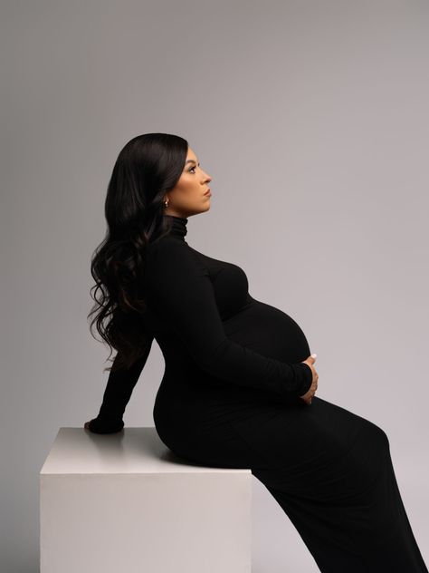 pregnant women wearing black dress indoors in a studio, sitting on white box, holding belly, for her maternity photos. Black Maternity Dress Outfit, Maternity Black Dress Outfit, Black Dress Maternity Shoot, Black Dress Maternity, Black Turtle Neck Dress, Studio Maternity Photos, Portraits Studio, Black Turtleneck Dress, Maternity Photoshoot Outfits