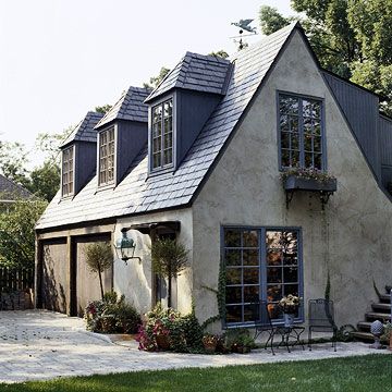 The perfect Tudor-style garage and guesthouse updated beautifully with a lively blue paint color for the trim. Tumbled Stone House Exterior, Dormers Ideas Exterior, Cottage House Exterior, Inlaw Suite, Carriage House Garage, Garage Door Styles, European Cottage, Small Cottage Homes, Small Cottages