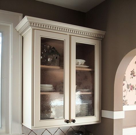 I refaced these cabinets with maple stock, prefinished in a glazed vanilla. Added a crown molding with dentil trim and used a seeded glass in the door. The end result fit the character of the 1925 bungalow in St. Charles, Illinois. Bungalow Kitchens, 1925 Bungalow, Kitchen Cabinet Molding, Stained Glass Cabinets, Crown Molding Kitchen, Dark Oak Cabinets, Dental Molding, Geneva Illinois, 1930s Bungalow