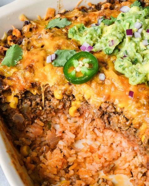 In this Mexican Casserole Recipe, zesty rice, refried beans, and seasoned ground beef are layered together, topped with cheese and baked. A delicious meal that's easy to make from scratch, or the perfect way to enjoy taco night leftovers! Refried Beans And Rice Casserole, Meals With Refried Beans Dinners, Ground Turkey Refried Beans Recipes, Mexican Casserole With Refried Beans, Things To Make With Refried Beans, Taco Casserole Bake With Rice, Mexican Noodle Casserole, Taco Casserole With Refried Beans, Refried Beans Casserole Recipe