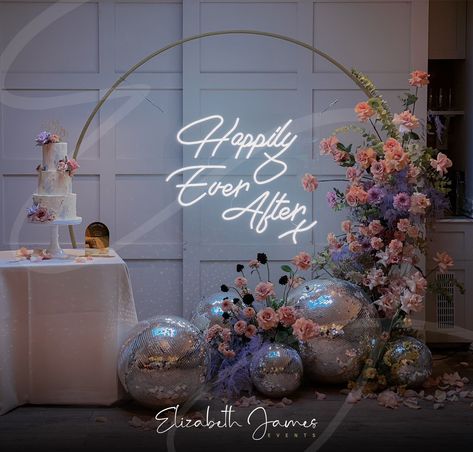 Disco balls and florals ✨The most beautiful cake table backdrop including our Neon 'Happily Ever After' Sign on Gold Moorgate frame 🌸🌿 Florist @rootedinrosemary Planner @emmareeveweddings Venue @the_great_house Cake @verityrosecakes Disco Ball Wedding Backdrop, Luxury Event Decor, Cake Table Backdrop, Table Backdrop, Disco Wedding, House Cake, Elizabeth James, Light Up Letters, Wedding Event Decor