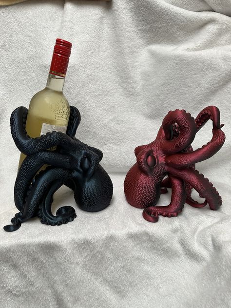 Size: Width: 8.5 inches            Height: 8.5 inches           Depth: 8.5 inches **Wine Bottle not included** Elevate your wine collection with our stunning 3D Printed Octopus Wine Holder. This eye-catching piece is the perfect addition to any wine lover's home decor. Our octopus wine holder is not only functional but also a work of art. Made from durable PLA materials, this wine holder can securely hold standard 750mL bottles. The octopus design adds a touch of whimsy and elegance to your coun Nerdy Kitchen Decor, 3d Print Camping, 3d Printed Wine Bottle Holder, Unique 3d Printing Ideas, Octopus Holding Things, 3d Print Decor, Diy Bar Decor, Cool Things To 3d Print, 3d Printer Ideas