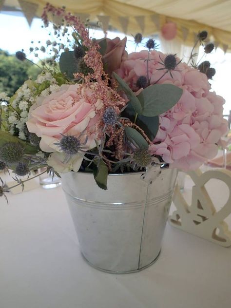 metal bucket centre piece arrangement Silver Bucket Centerpiece, Flowers In Tin Bucket, Flowers In Metal Buckets, Metal Bucket Centerpieces, Bucket Flower Arrangements, Tin Bucket Centerpiece, Bucket Centerpiece Ideas, Galvanized Buckets Wedding, Bucket Centerpiece