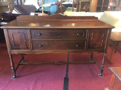 Item: Antique Jacobean Sideboard in Walnut by the Lenox Shop. Age & Condition: Circa 1920. Refinished and restored. Dimensions: 66″ wide x 24″ deep x 42.5″ tall (38″ not including the backsplash). Nice antique sideboard with a very pretty look. This antique Jacobean Style buffet has good storage and is quite stylish! Antique Sideboard The antique sudeboard features two drawers flanked by cabinet doors on either side. Of course, this provides nice storage for table linens or serving pieces. The sideboard sits on tall turned legs with a stretcher base. Also, each cabinet door features beautiful walnut trim and veneers. Jacobean Style Buffet This Jacobean Style buffet shows well and has a nice look. We refinished it in order to bring back the beauty of the wood. The sideboard features a maker Antique Buffet Table, Jacobean Sideboard, Jacobean Buffet, Sideboard Walnut, Antique Sideboard Buffet, Walnut Buffet, Buffet Furniture, Jacobean Style, Buffet Vintage