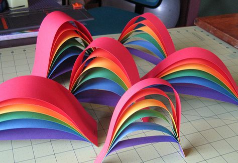 paper strip rainbows.  Super easy!  Really cute! Could use any colors for any occasion. Can staple together to make a garland.  Stapled 6 together in a "circle" and sat a bowl of snacks in the middle. Put the tops of the rainbows toward the inside. A tad heavy for easy hanging, though. Rainbow Table Decorations, Library Preschool, Rainbow Table, Camp Crafts, Craft Craft, Folded Paper, Rainbow Birthday Party, Rainbow Crafts, Sunday School Crafts