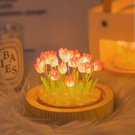 The Tulip Glass Night Light is made of glass and shaped like a small glass ball. The lamp base is a wooden base, which emits a soft yellow glow, adding a warm atmosphere to the room.The exterior of this night light is transparent, allowing you to see the petals and stems inside, just like a real tulip in bloom. Some tulip night lights also have stained glass, which can show brilliant colors under the light, which is very beautiful.The Tulip Glass Night Light is a great decorative addition to any Tulip Night Light, Aesthetic Lights, Kou Diabolik Lovers, Tulip Lamp, Flower Tulip, Cute Night Lights, Fav Products, Flower Bedroom, Ball Lamps