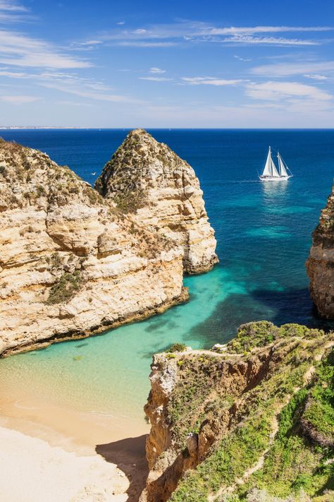 Aerial view of white-sand beach between cliffs and sailing boat in bright blue sea. Algarve Portugal Aesthetic, Portugal Aesthetic Albufeira, Algarve Travel, Portugal Aesthetic Algarve, Lagos Portugal Beach, Portugal Beach, Cap Vert, Villa With Private Pool, Algarve Portugal