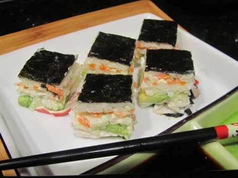 SIMPLE STACKED SUSHI ~ I’ve tried the roll-your-own sushi and it works–sometimes. A couple years ago, I came across a recipe for stacked sushi in a cookbook titled “Bite Me” and had to try it. And modify it. It’s now a family favorite–easy to make and less expensive than restaurant- or store-bought sushi. Our family prefers sushi with pre-cooked shrimp or imitation crab, but if you’re more adventurous, you can substitute raw fish. Stacked Sushi, Layered Sushi, Sushi Recipes Homemade, Shrimp Sushi, Seafood Sushi, Sushi Bake, Sushi Japanese, Sushi At Home, Sushi Love