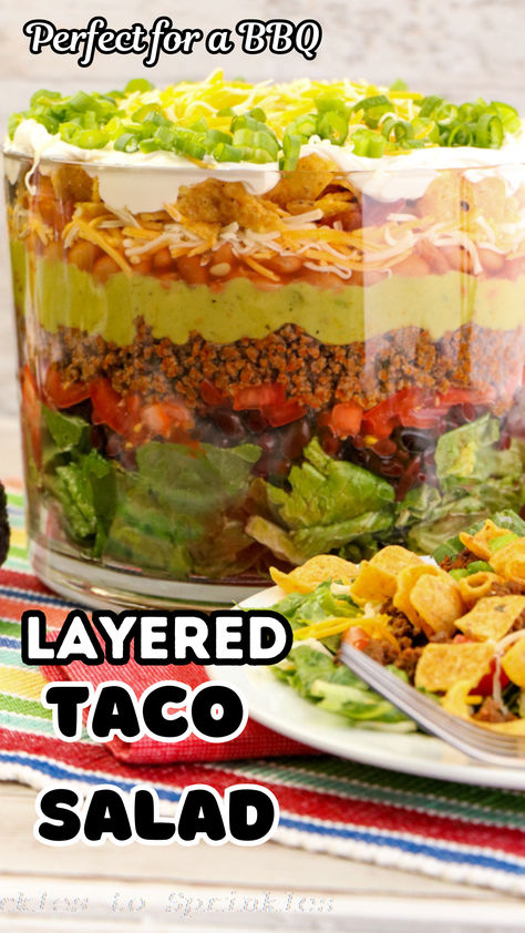 Layered Taco Salad Recipe: Perfect for summer gatherings, this easy and delicious salad combines romaine lettuce, beans, cheese, guacamole, and more! Fresh, flavorful, and fun to make, it's a crowd-pleaser that's sure to impress. Save this recipe for your next BBQ or potluck! Layered Taco Salad In A Cake Pan, Seven Layer Taco Salad Recipe, Layered Taco Salad Recipe, Layered Taco Salad, Layered Taco Salads, Layered Taco, Taco Salad Recipe, Taco Salads, Trifle Dish