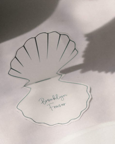 This elevated Shell Shaped Place Card is perfect for your next wedding, bridal shower, baby shower or event.  You can instantly download the editable template and begin placing your names. INSTANTLY EDIT WITH CANVA After your purchase, you will receive a link with a PDF file to your Shell Place Card Template within minutes of ordering. Open your email, click the link and upload your PDF file to Canva. You can edit the template immediately in your browser using Canva. We recommend duplicating each page and replacing the name content to ensure the size and shape stay consistent prior to printing. Upon the centre line, this is where you fold the place card to sit on the table like in the image above.  DOWNLOAD INCLUDES 15cm x 15cm Art board  Shell Design  Name text YOU CAN EDIT - Text - Font Seashell Place Cards Wedding, Dinner Name Place Cards, Place Cards Ideas, Name Cards For Wedding, Coastal Chic Wedding, Shell Place Cards, Unique Place Cards, Wedding Name Place Cards, Name Place Cards Wedding