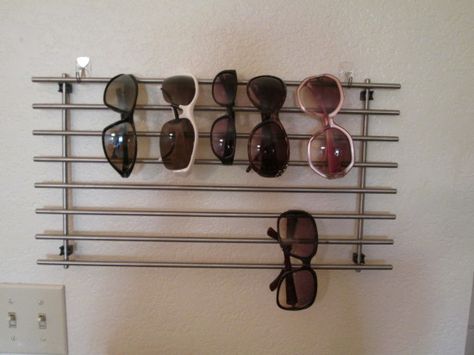 Sunglass display - IKEA Hackers ~ Needed a quick, cheap way to hang your sunglasses?…Ikea hack comes through! 3M Command hooks (no damage to the apt walls) and a little used IKEA LÄMPLIG Trivet (cooling rack) Read more at http://www.ikeahackers.net/2014/07/sunglass-display.html#kWFkTjLTDMr8vDmQ.99 Ikea Trivet, Sunglass Hanger, Sunglass Rack, Wall Display Ideas, Diy Sunglasses Holder, Sunglasses Rack, Sunglass Display, Diy Sunglasses, Ikea Organization Hacks