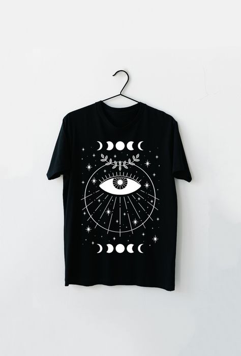 Embrace your dark allure with our Gothic Eye Shirt, the perfect embodiment of witch aesthetic. This Evil Eye Unisex Jersey Tee features a captivating design that showcases a mesmerizing evil eye. Let your unique style shine through and make a statement wherever you go. Upgrade your wardrobe today with this must-have piece! Eye Shirt, Goth Shirt, Aesthetic Shirt, Clothing Designs, Aesthetic Shirts, Witch Aesthetic, Alt Fashion, Goth Outfits, Jersey Tee