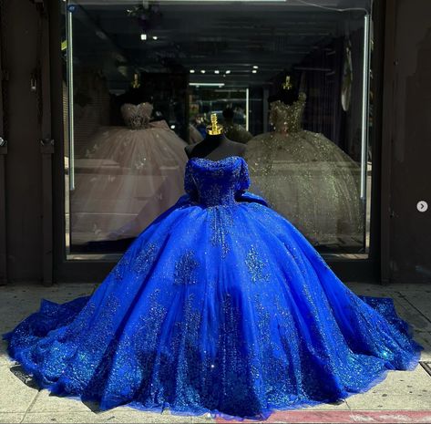 Details: Silhouette: Ball-Gown Style Fabric: Tulle Fabric Color: Royal Blue Color Length: Chapel-Train Neckline: Off-the-Shoulder Neckline Sleeves: Sleeveless Back: Lace-Up Back Embellishment: Appliqued, Bow-Knot Chambelanes Outfits Quinceanera Blue, Quinceanera Dresses With Train, Chambelan Outfits, Blue Quince Dress, Royal Entrance, Royal Blue Ball Gown, Gowns Pageant, Royal Blue Quinceanera Dresses, Quince Planning