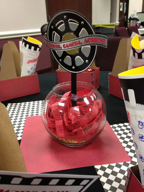 Movie theatre themed decor used for our big annual training. These are the centerpieces in each table - a fish bowl with popcorn kernels, tickets, and a movie reel. Also used scrapbook paper as a background to set the centerpiece on. Movie Themed Table Centerpieces, Hollywood Birthday Parties, Oscars Party Ideas, Cinema Party, Red Carpet Theme, Dance Theme, Hollywood Birthday, Movie Birthday Party, Hollywood Party Theme