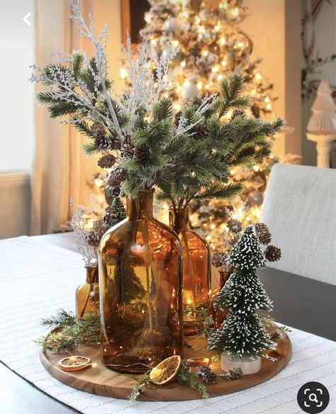 Amber Vase Christmas Decor, Amber Bottle Centerpiece, Amber Glass Christmas Tree, Wedding Centerpieces Christmas, Small Holiday Centerpieces, Amber Glass Christmas Decor, Christmas Vase Centerpiece Ideas, Amber Bottles Decor, Amber Christmas Decor